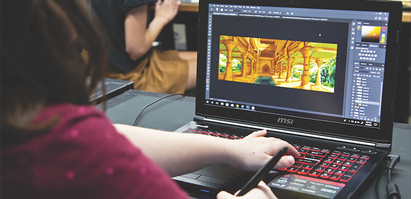 A photo of a student working at a laptop.