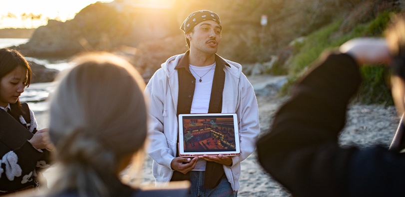 A photo of a student giving a presentation on the beach.