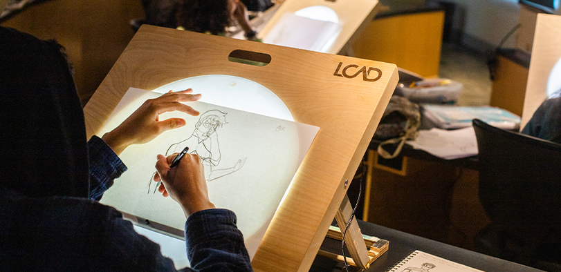 A photo of a student at a light table.