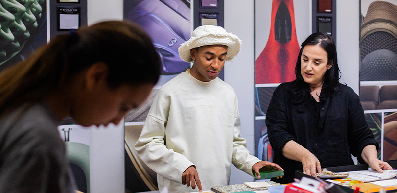 A photo of an instuctor showing a student textiles.