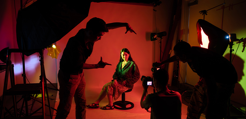 A photo of students working in the green screen room.