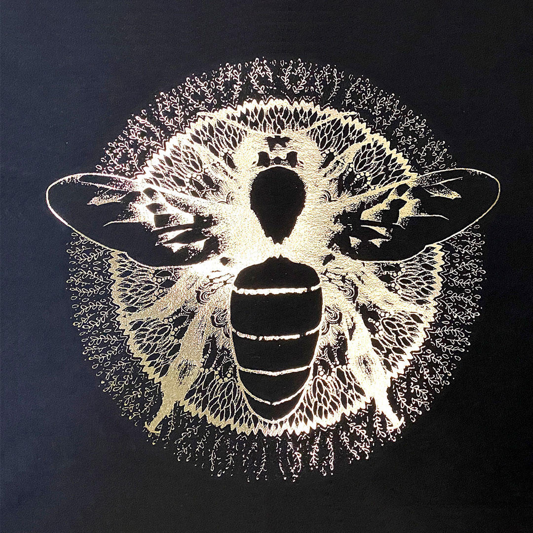 A photograph of a bee in a circle as a print block, and next to it is the print it made on a piece of black paper.
