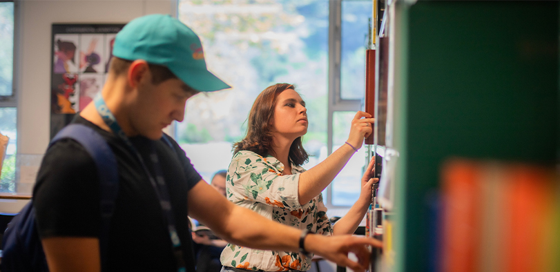 A photo of students looking at books in the Big Bend library.