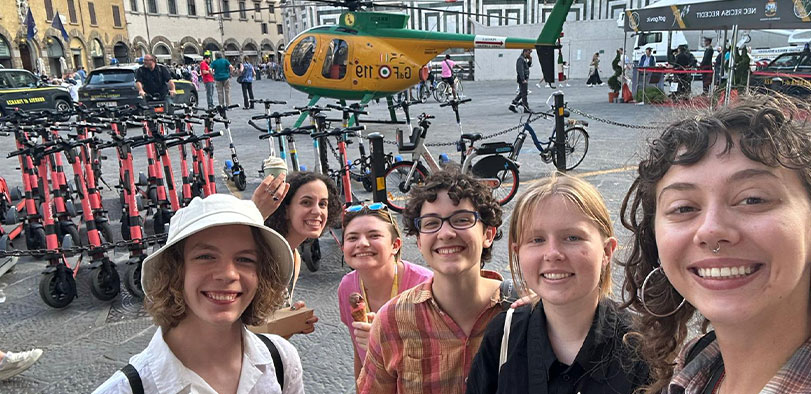A photo of students posing in front of bicycles