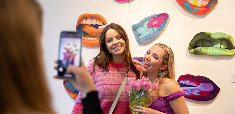 A photo of two students posing at the LCAD Gallery.