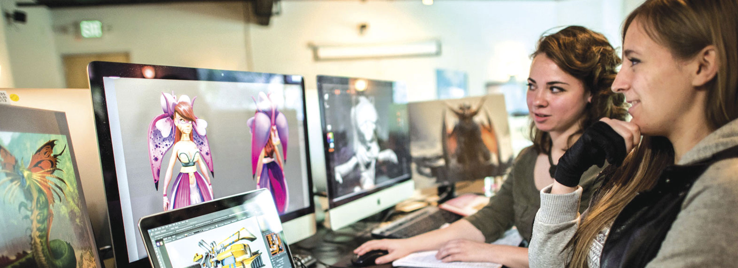 A photo of two students working at a computer.