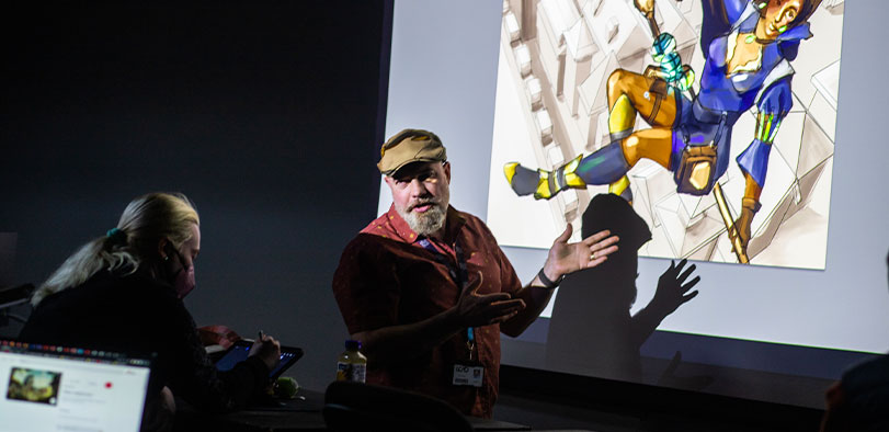 A photo of a faculty member teaching in a classroom.