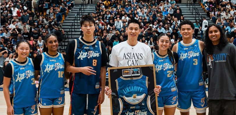 A photo of Brandon Tam standing with athletes wearing his uniform designs.